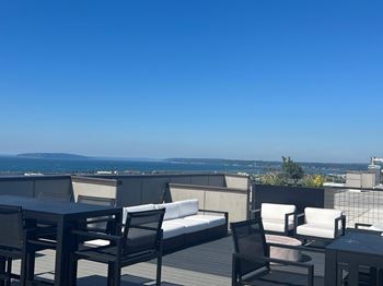 a roof deck with a view of the city and the ocean